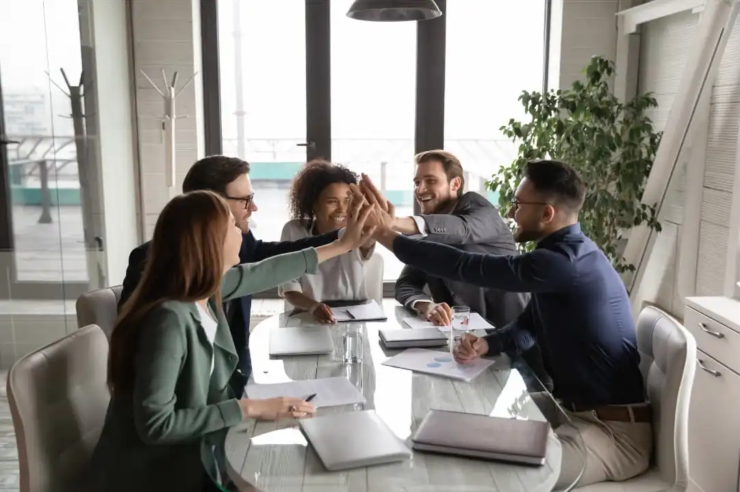 A team happily holding their hands together up high during employee engagement