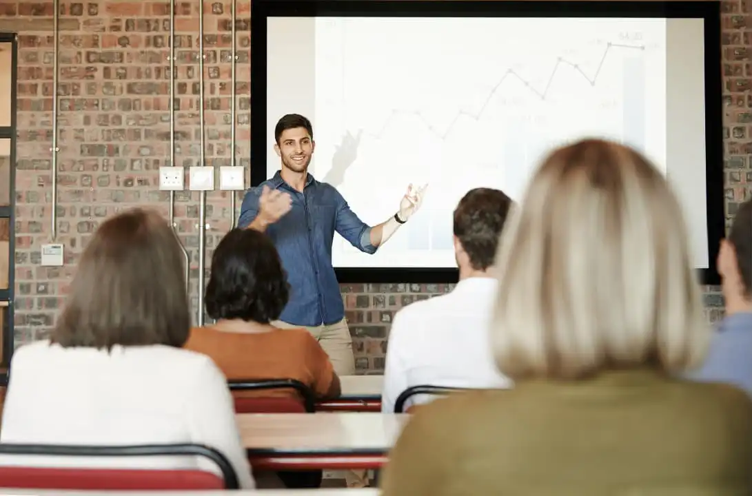 A man presenting in front of a crowd to engage his employees