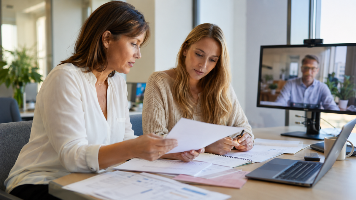 People leader and payroll specialist reviewing employment and payroll documents for a first European tech hire